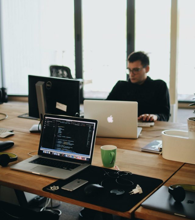 pexels-photo-2102416-2102416 A web developer working on code in a modern office setting with multiple devices.